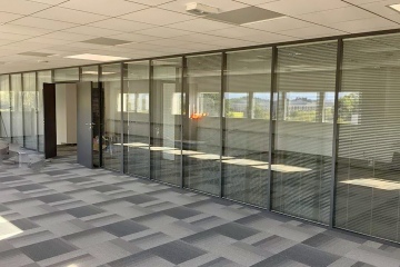 Прозрачные перегородки с жалюзи для естественного освещения и приватности в офисном помещении